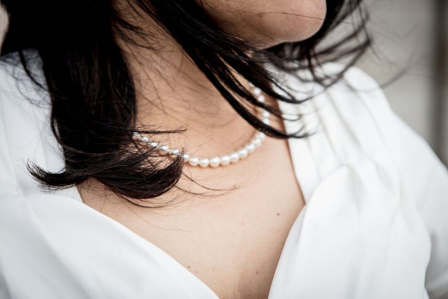 A pearl choker worn close at the neck in soft daylight.
